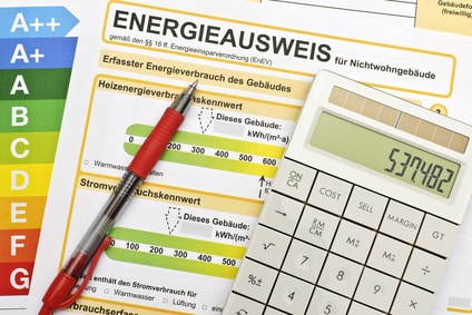 Ein Energieausweis für Nichtwohngebäude und ein Rechner, welcher den Energieverbrauch ausrechnet.